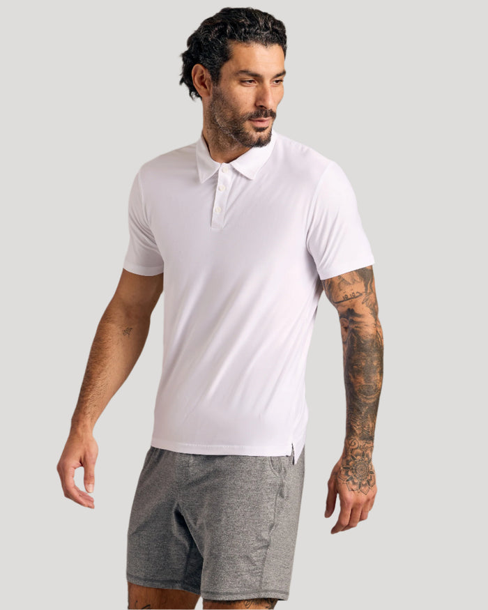 Man wearing Black & White Active Polo, showcasing athletic fit and tattooed arm.