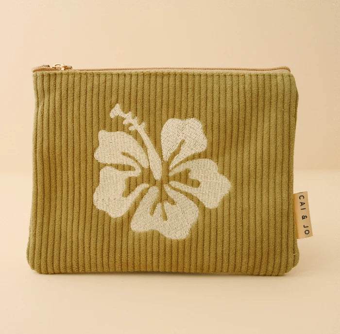 Green ribbed cai and jo pouch with a white floral design on a beige background