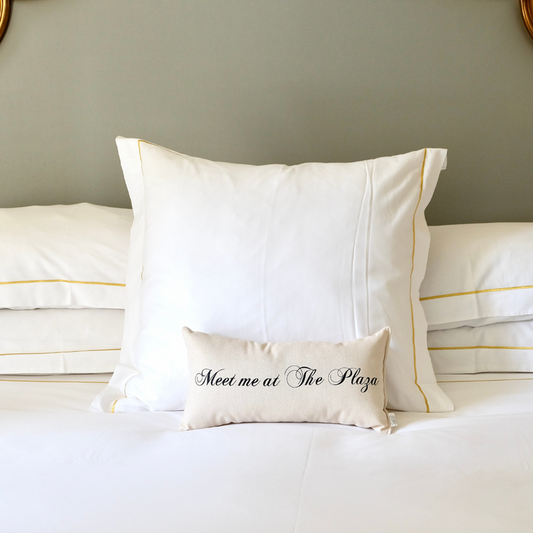 Meet Me at The Plaza pillow on a white bed