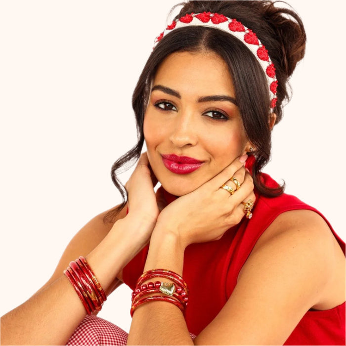 a woman in red with her hands on her cheeks