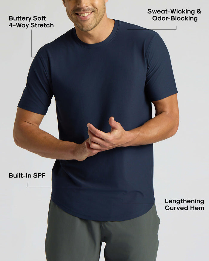 Man wearing a navy navy active curved hem crew shirt with sweat-wicking, odor-blocking fabric, buttery soft 4-way stretch, built-in SPF, and a lengthening curved hem.