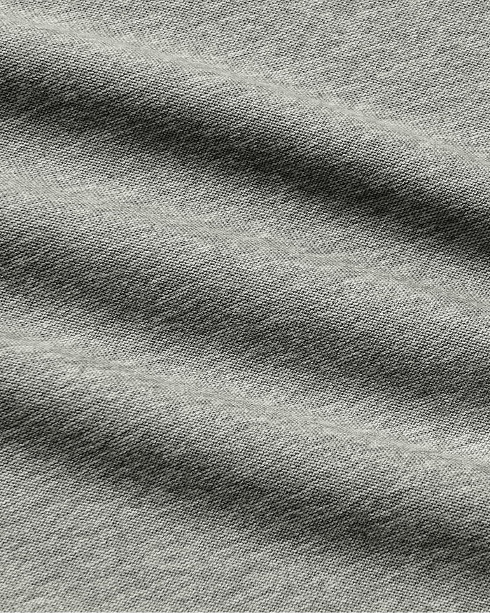 Close-up of a heather gray fabric texture with soft folds and a woven slub pattern.
