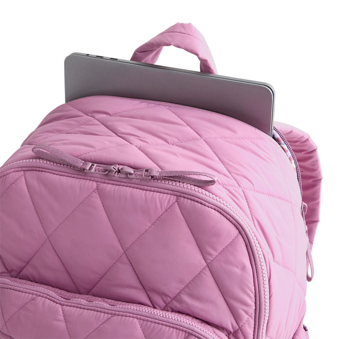 Pink quilted backpack with a tablet on a white background