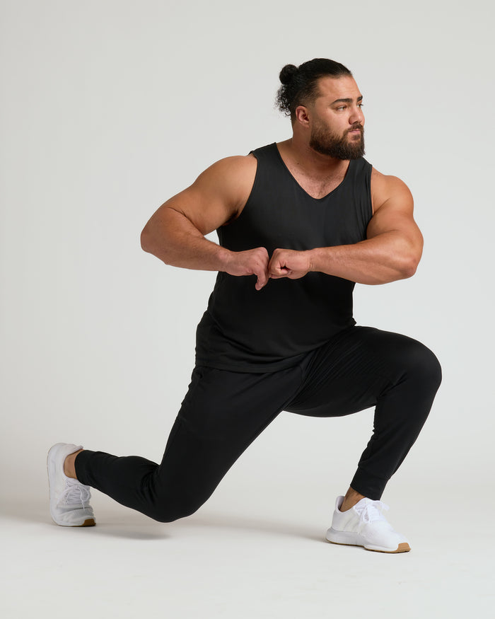 Man in Black Sleeveless Active Mesh Tank 3-Pack lunging in studio.