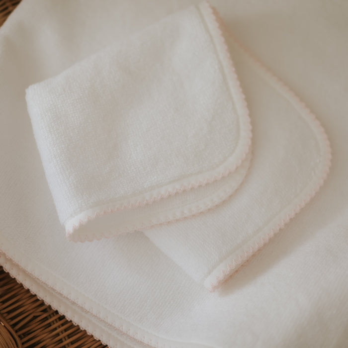 Folded white towel with picot trim