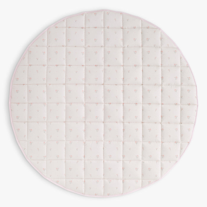 Round quilted play mat with a pink floral pattern on a white background