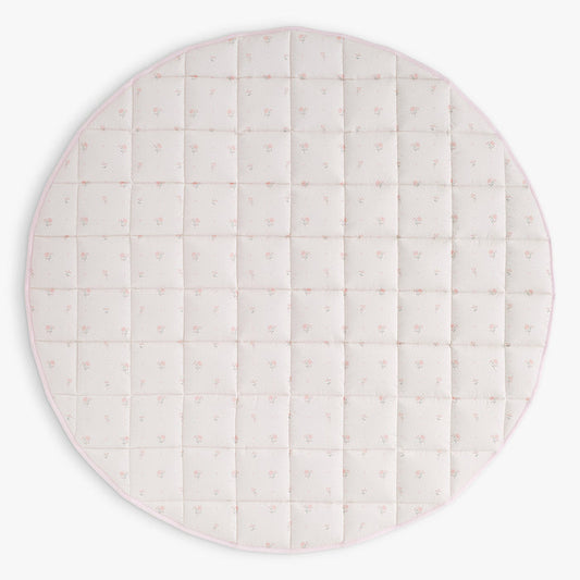 Round quilted play mat with a pink floral pattern on a white background