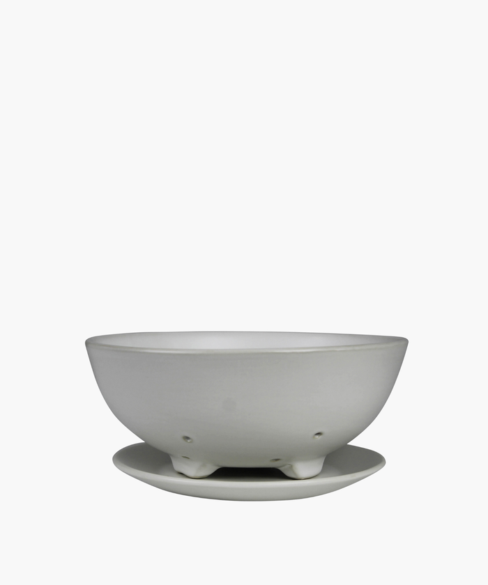 White ceramic colander with matching base plate. The minimalist design features a smooth matte finish, subtle curves, and small drainage holes. | SW Home