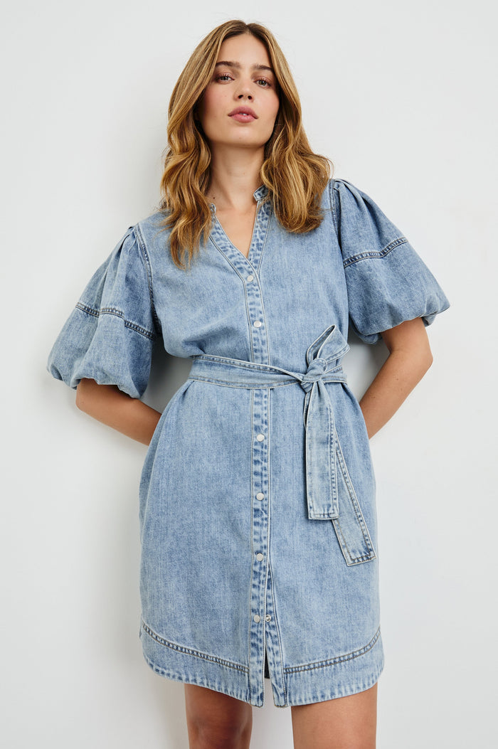 Kingsley Denim Mini Dress with Elbow-Length Puff Sleeves, a V Neck, Snaps Down the Front and a Fabric Tie Belt in Faded Indigo Colorway - Front View Featured on Model