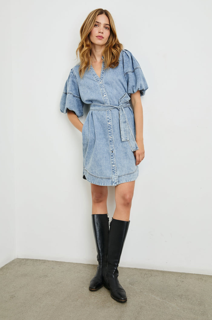 Kingsley Denim Mini Dress with Elbow-Length Puff Sleeves, a V Neck, Snaps Down the Front and a Fabric Tie Belt in Faded Indigo Colorway - Front Full Body View Featured on Model