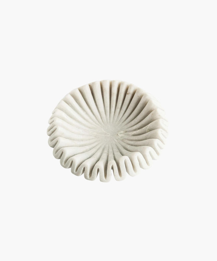 Overhead view of an elegant white marble bowl with a pleated, fan-like design. Its sculptural form and soft shadows create a minimalist and artistic appeal. | Wildwood Home Co.