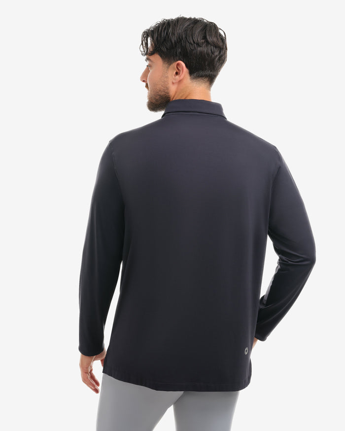 Man wearing a black long-sleeve shirt and light gray pants on a white background