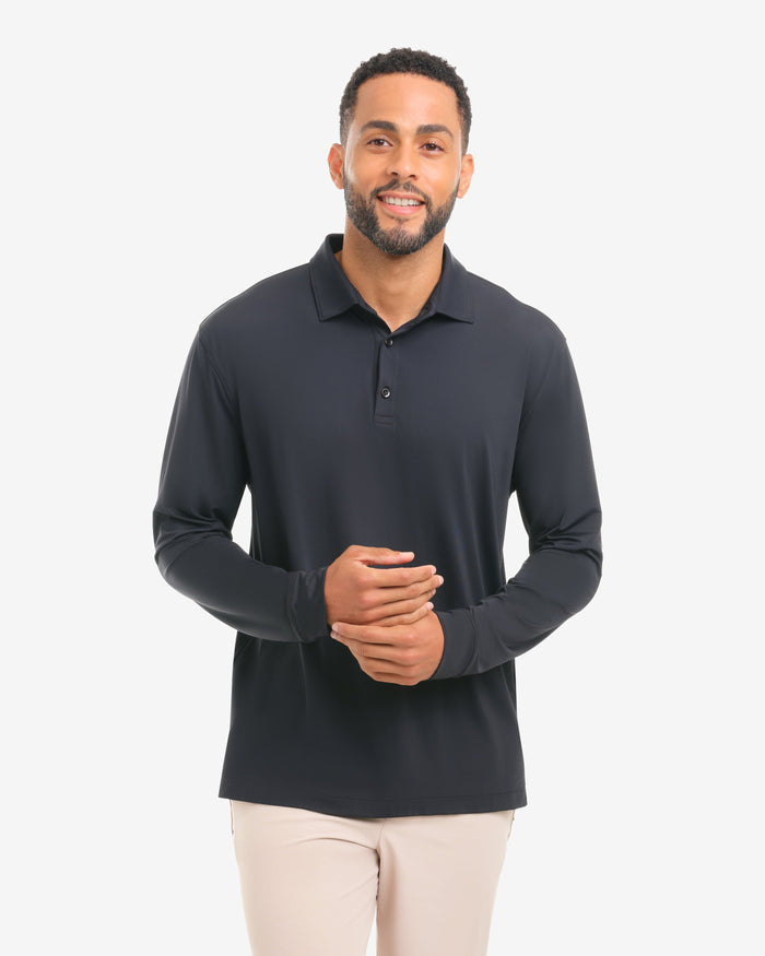 Man wearing a black long-sleeve polo shirt and beige shorts on a white background