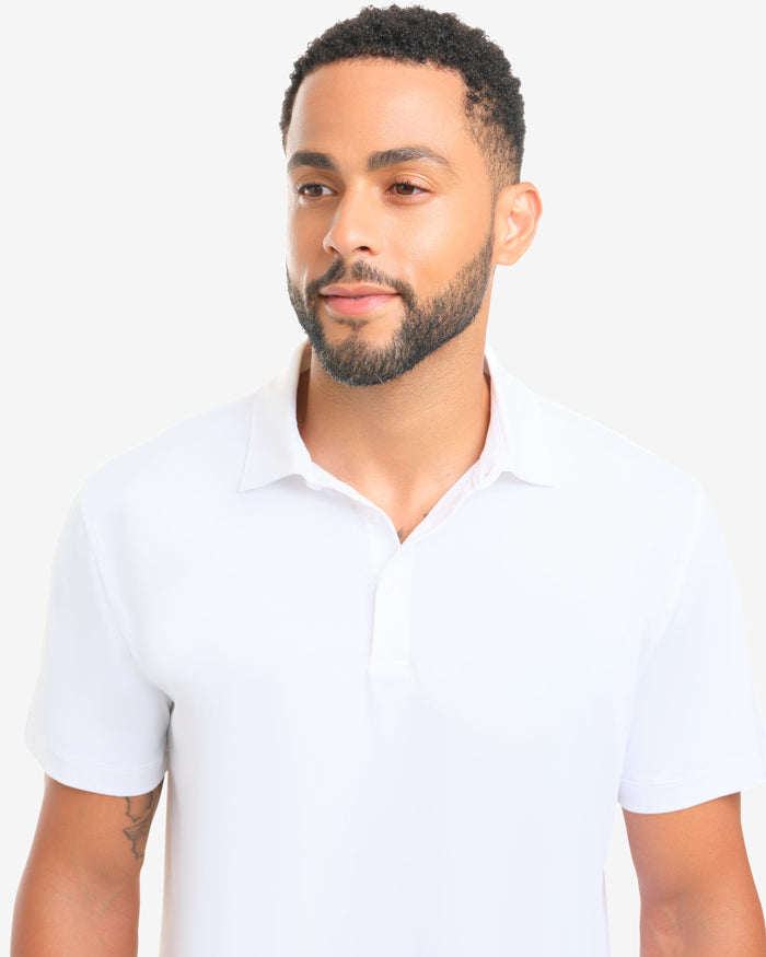 Man wearing a white polo shirt against a plain background