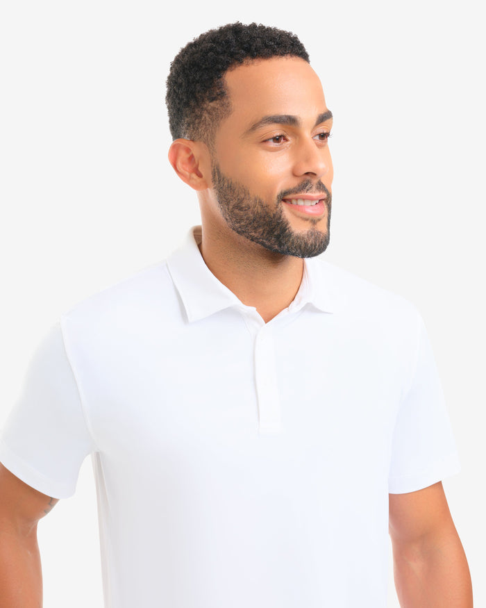 Man wearing a white polo shirt against a plain background