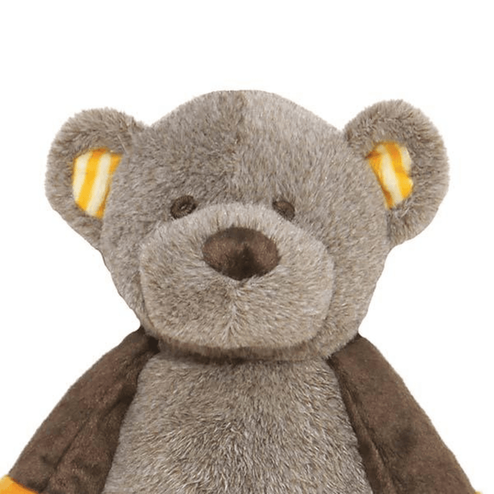 Close up of head of teddy bear toy dog with brown head and body with stripy orange fabric inside the ears, stitched eye and nose details pictured on a white background.