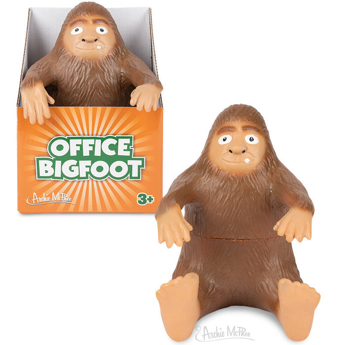 Boxed toy figurine depicting a smiling Bigfoot, set against an orange starburst background, labeled as Office Bigfoot—ideal for bringing some playful charm to your desk.