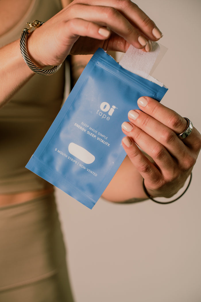 model taking a single non-vented oi tape mouth tape strip out of the package