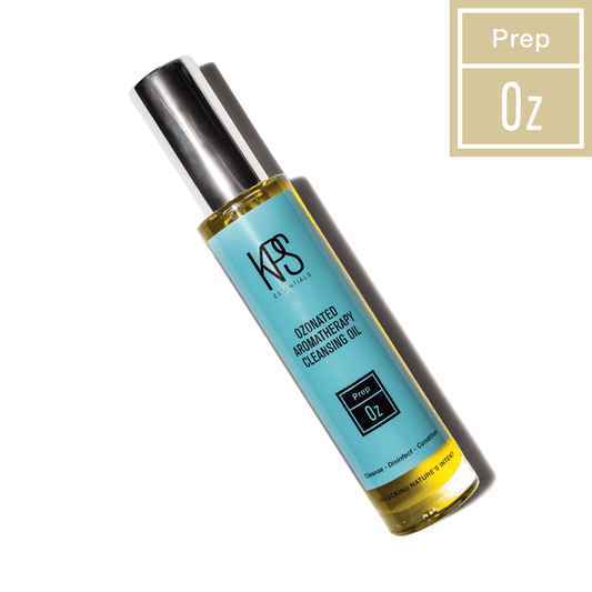 Bottle of Ozonated Aromatherapy Cleansing Oil | Kindness Powered Skincare with blue label and silver cap on white background with soft shadow and "Prep 0z" badge in beige tone.