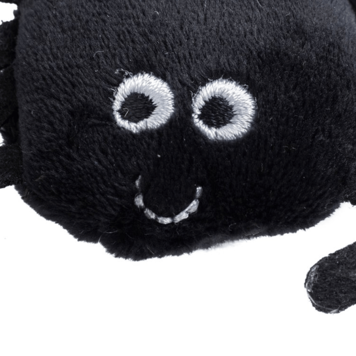 Close up of face of black spider cat toy with stitched eye and smile details. On a white background.