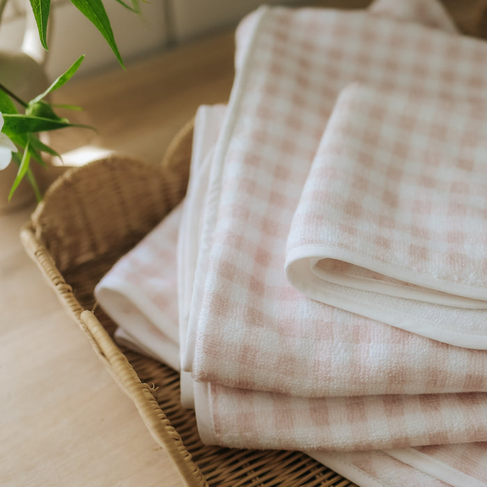 Baby hooded towel in Pink Gingham in a stack.