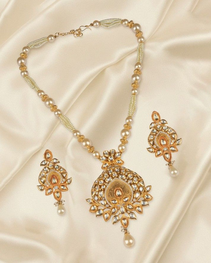 Kundan pearl pendant set with gold-toned pendant and dangling pearl drops, plus matching earrings