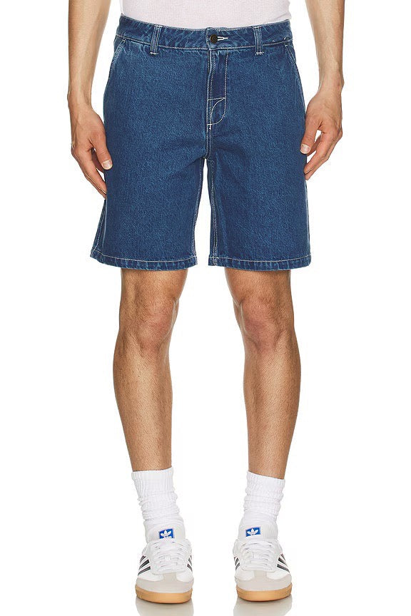 Person wearing dark wash rhythm denim shorts on a white background