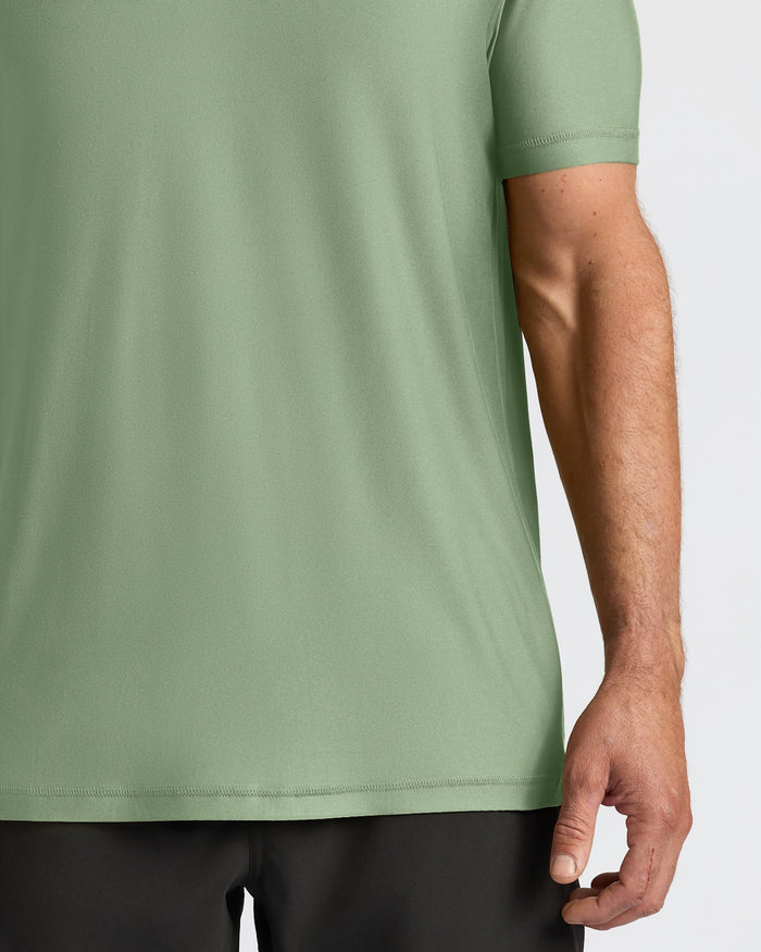 Person wearing a green t-shirt with a neutral background