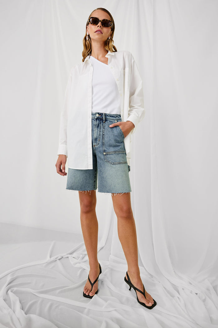 Slater high rise bermuda short with carpenter style details in Blueprint - stylized front view on model with hand in pocket