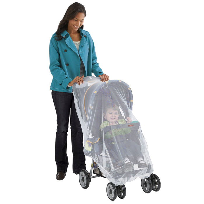 A woman in a teal coat and dark pants pushes a stroller covered with Stroller Insect Netting | White, keeping the smiling child inside protected from bugs.