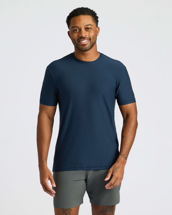 Man wearing Navy Active Crew Neck Tee and olive-green shorts, smiling.