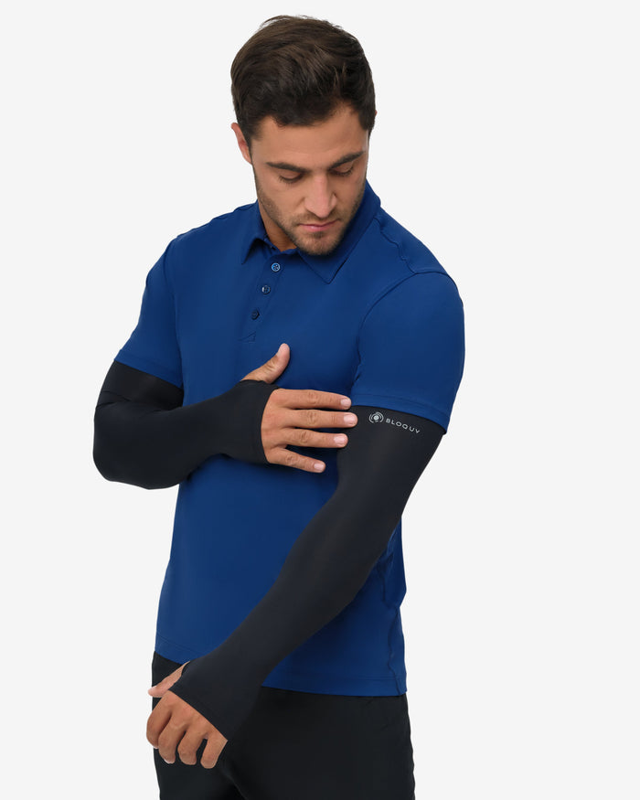 Man wearing a blue shirt with black arm sleeves on a white background