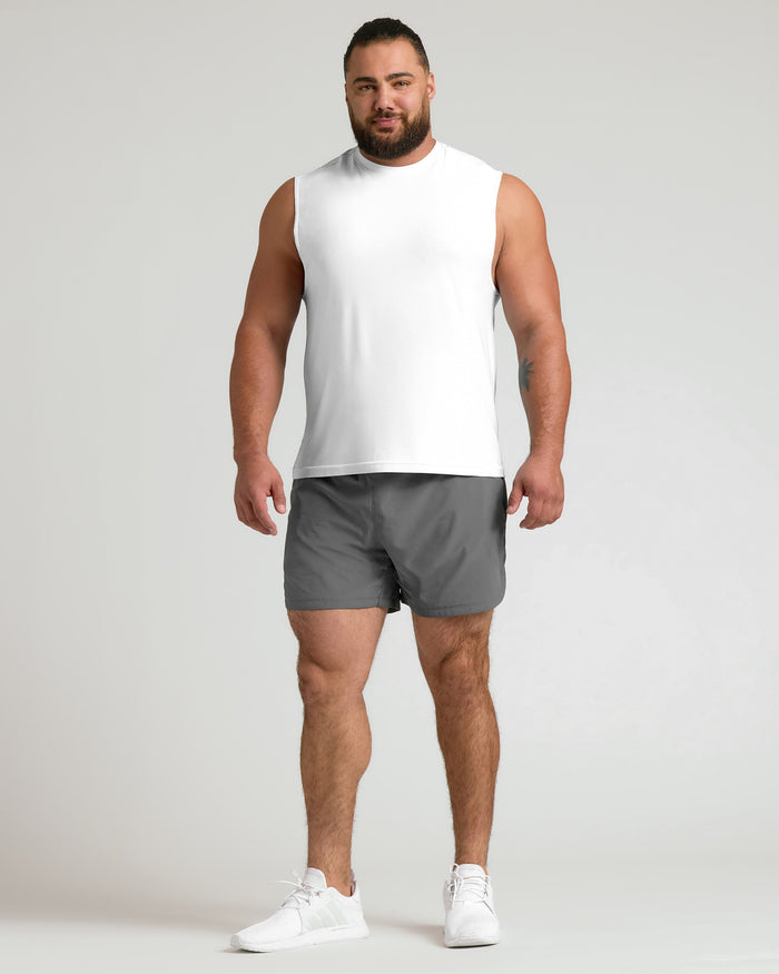 Man in White Sleeveless Active Muscle Tee, gray shorts, white sneakers.